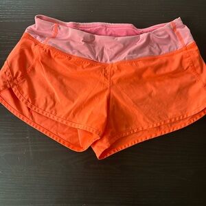 Orange and Pink Athletic Shorts with Elastic Waistband and Curved Hem